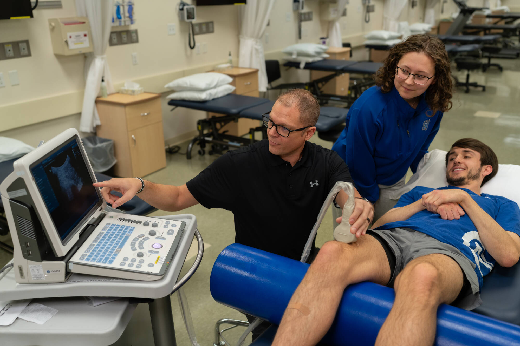 Students and instructor practicing ultrasound techniques in lab